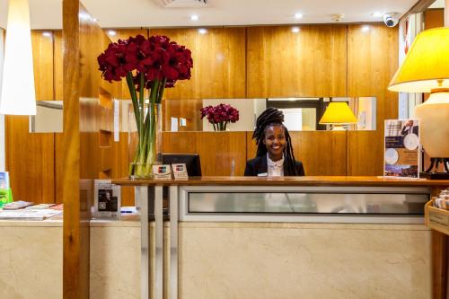 a woman standing in front of a counter in a kitchen at Island Club Hotel & Apartments in Cape Town