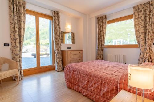 a bedroom with a bed and a large window at Monte Cervino Apartment AS21 in Breuil-Cervinia