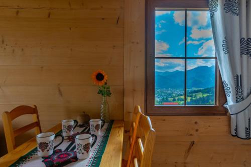 a dining room with a table and a window at Domki na Gubałówce in Zakopane