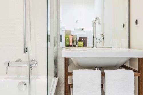 a bathroom with a sink and a mirror at Hotel Joke - Astotel in Paris