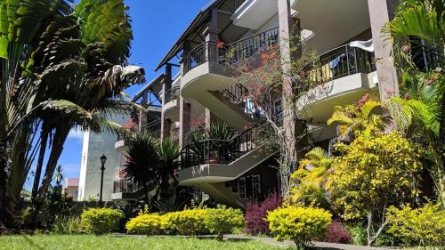 a building with a spiral staircase in a garden at Lharmonie Villa in Pereybere