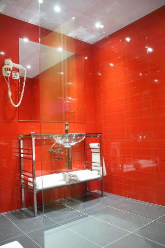 a red bathroom with a shower and a sink at Hotel Indiana in Pinto