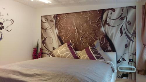 Schlafzimmer mit einem Bett mit einem großen Kopfteil in der Unterkunft Ferienwohnung Heyne in Weinböhla