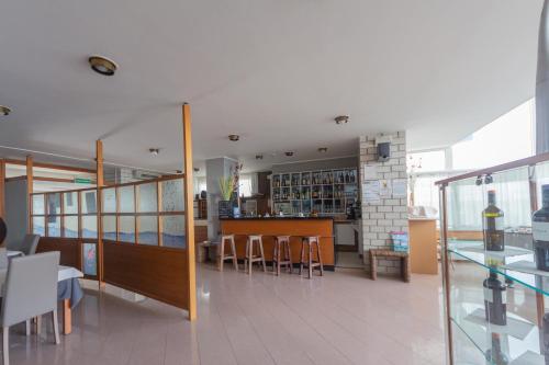a restaurant with a bar and some tables and chairs at Hotel Ambra in Lignano Sabbiadoro