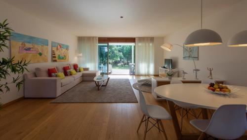 a living room with a table and a couch at Troia Residences - Beach Houses in Troia