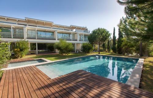 a swimming pool in front of a house at Troia Residences - Beach Houses in Troia