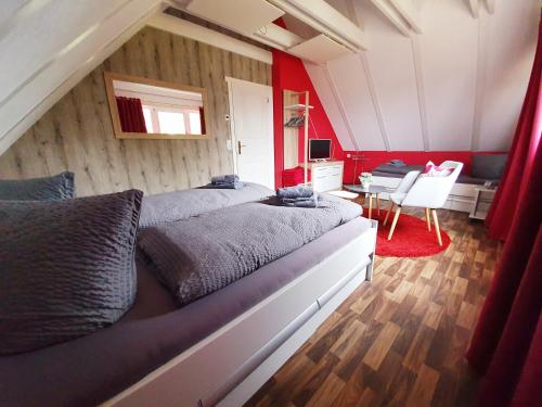 a bedroom with two beds and a red wall at Ferienhäuser Oberdorla in Oberdorla