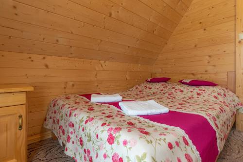 a bedroom with two beds in a wooden cabin at Domki na Gubałówce in Zakopane
