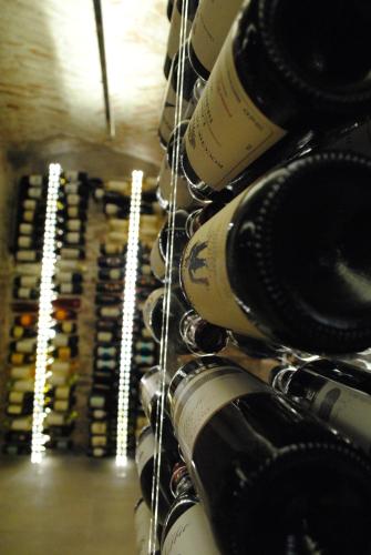 a bunch of wine bottles lined up on a rack at Vinoteca La Sacrestia in Alba