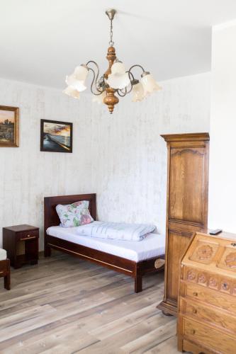 een slaapkamer met een bed en een kroonluchter bij Agroturystyka Jaśmina in Warnice