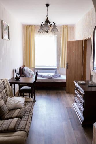 een woonkamer met een bank, een tafel en een raam bij Agroturystyka Jaśmina in Warnice