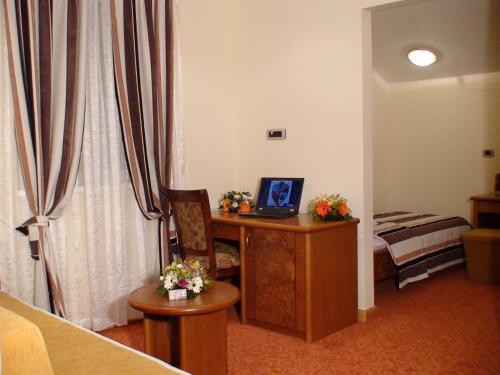 um quarto com uma secretária e um computador portátil. em Garni Hotel BaMBiS em Podgorica