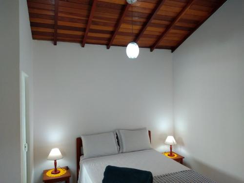 Chalés Vale dos Pássaros tesisinde bir odada yatak veya yataklar