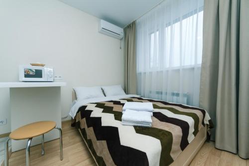 a small bedroom with a bed and a chair at My SmartApart Hotel Today in Kyiv