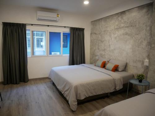 um quarto com 2 camas e uma janela em NP House Pratunam em Bangkok