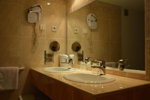 a bathroom with two sinks and a large mirror at Hotel Panda in Pas de la Casa