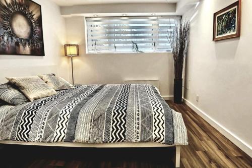 Schlafzimmer mit einem großen Bett, einem Fenster und einem Fenster in der Unterkunft Cosy apartment at Bossuet road in Montreal