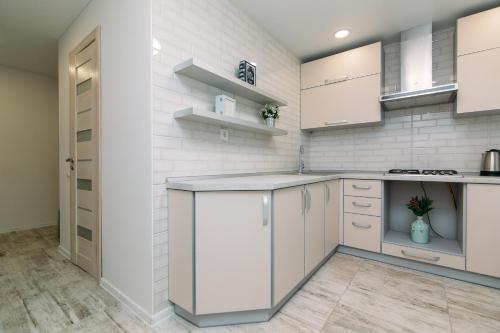 a kitchen with white cabinets and a counter top at Luxury Apartment neer Manufaktura on Kharkovskaya in Sumy