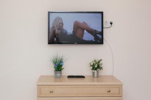 a tv hanging on a wall above a dresser at Luxury Apartment neer Manufaktura on Kharkovskaya in Sumy