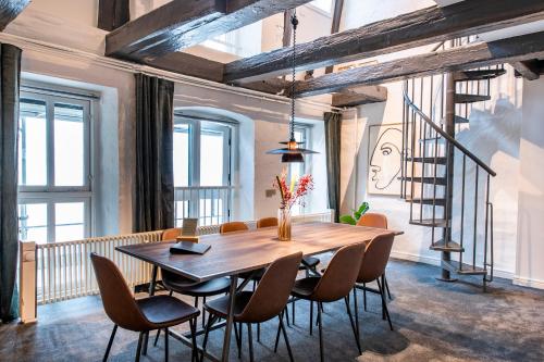 uma sala de jantar com uma mesa de madeira e cadeiras em The Churchill Penthouse by Daniel&Jacob's em Copenhaga