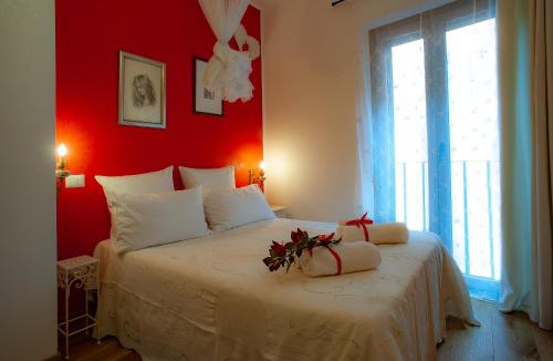 a bedroom with a white bed with a red wall at B&B Buonfiglio Cicconcelli - Terrazza panoramica in Frascati