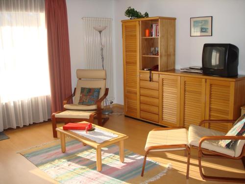 a living room with a tv and a coffee table at Residenz La Mora in La Punt-Chamues-ch