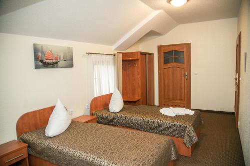 a hotel room with two beds and a window at Hotel Oaza in Prudnik