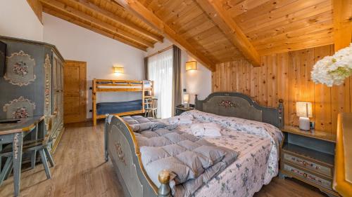 een slaapkamer met een bed en een stapelbed bij Hotel Brunella in San Vigilio Di Marebbe