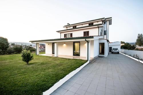 a white house with a driveway and a yard at Viana do Castelo Home in Viana do Castelo