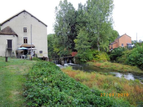a river next to a house and a building at Dependance du Moulin Galuzot in Saint-Vallier