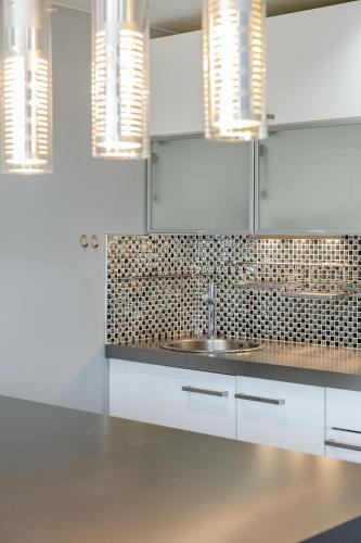 une cuisine avec des armoires blanches et un évier dans l'établissement Le Bosquet 1 par Dodo-a-Cassis, à Cassis