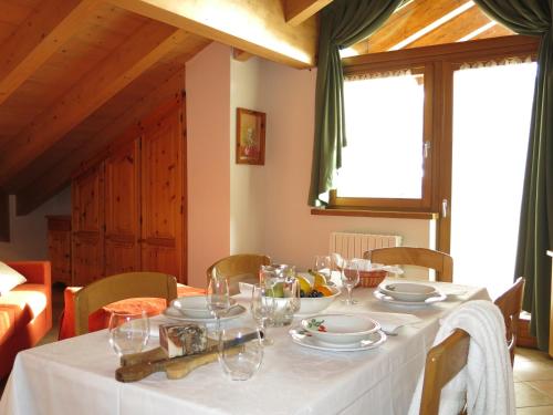 a dining room table with a white tablecloth on it at Baita al Pian in Bormio