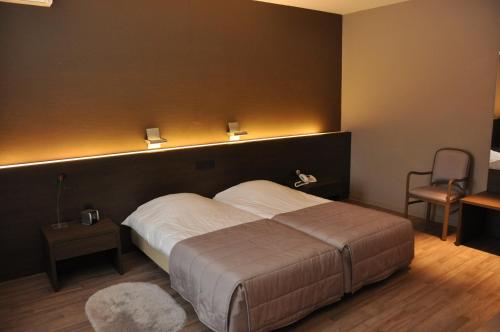 a bedroom with a large bed with a black wall at Hotel De Zalm in Oudenaarde