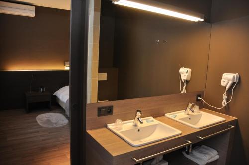 a bathroom with two sinks and a mirror at Hotel De Zalm in Oudenaarde