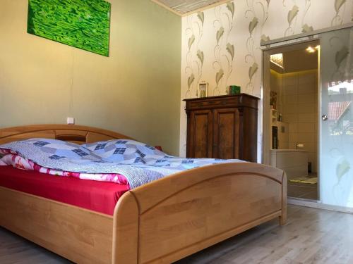 a bedroom with a wooden bed and a shower at Ferienwohnung Harzerfuchs in Wernigerode