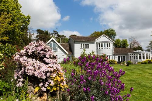 a white house with flowers in the yard at Squirrel in Southwold