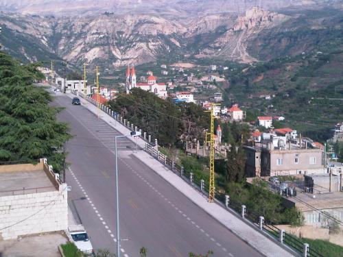a view of a street with a city and mountains at Hotel Chbat in Bcharré