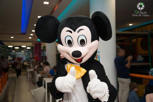 a person dressed in a mickey mouse costume eating food at Diamond Hill Resort & SPA in Vlorë