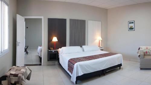 Habitación de hotel con cama grande y escritorio. en Samay Hotel Boutique en Colonia Dora