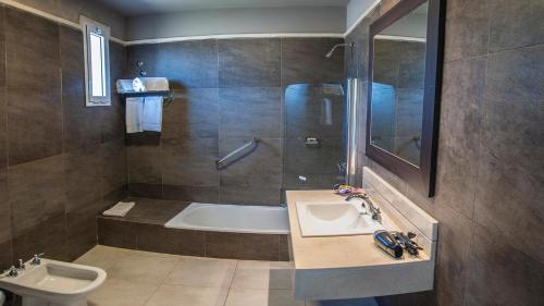 Un baño con bañera, lavabo y ducha. en Samay Hotel Boutique, en Colonia Dora