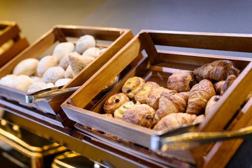 two wooden boxes filled with different types of pastries at B&B HOTEL Brussels Centre Gare du Midi in Brussels