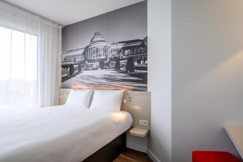 a bedroom with a bed with a drawing on the wall at B&B HOTEL Brussels Centre Gare du Midi in Brussels