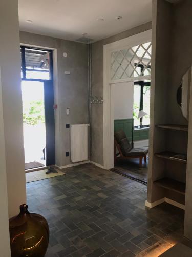 a hallway with a living room with a glass door at Tree Top Hill - The Old Station House - Båstad Holiday Apartments in Båstad
