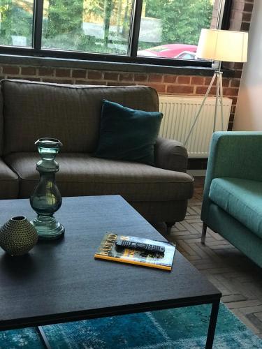 a living room with a couch and a coffee table at Tree Top Hill - The Old Station House - Båstad Holiday Apartments in Båstad