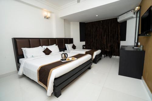 A bed or beds in a room at Hotel Mangalore International