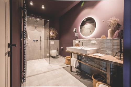 ein Bad mit einem Waschbecken und einer Dusche in der Unterkunft Saltbloom Apartments in Lüneburg