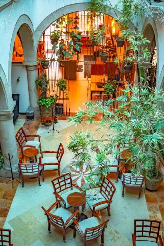 a group of tables and chairs in a room with plants at Hostal de La Monja in Durango
