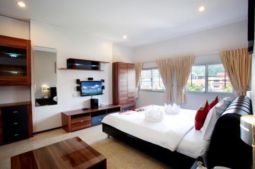a hotel room with a bed and a television at U Sabai Living Hotel in Patong Beach