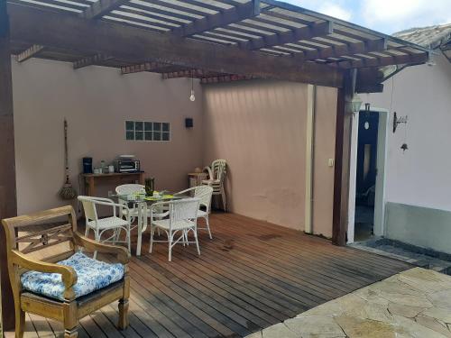 a patio with a table and chairs on a deck at Loft Aconchego da Serra in Petrópolis