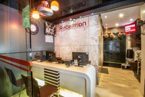 a restaurant with a reception desk in a room at Aishwarya Suites in Mysore